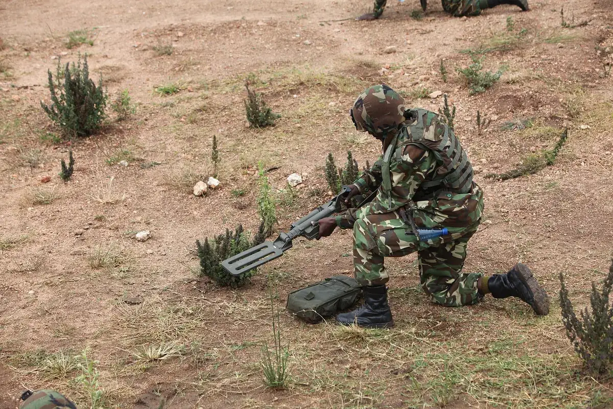Soldier checking the ground with a detector during an exercise