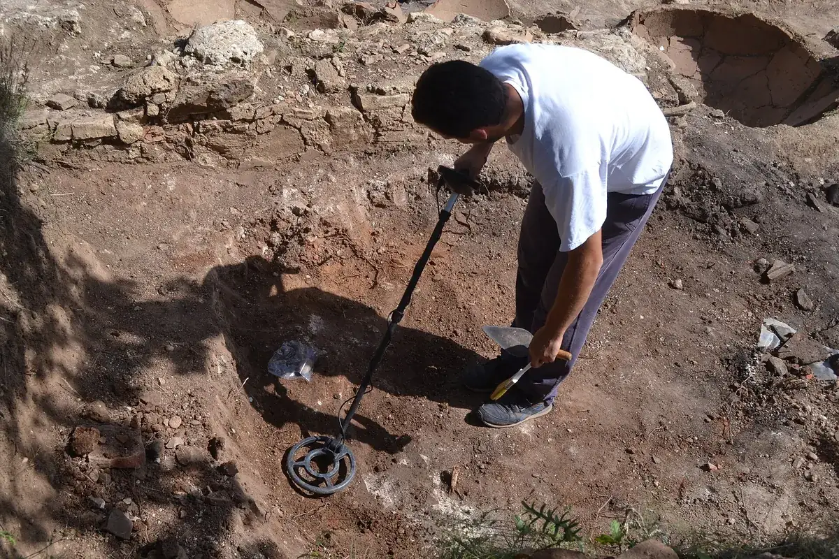 Metal detector in use in an open trench